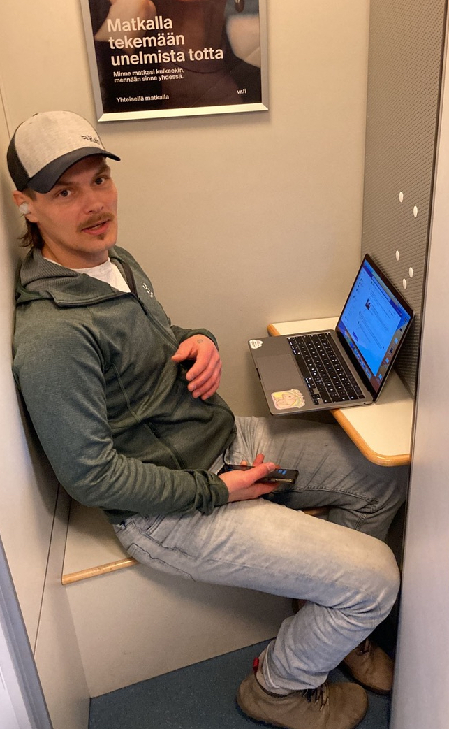 Tomas Luoto aikuisena tietokoneen ääressä junan työskentelytilassa.