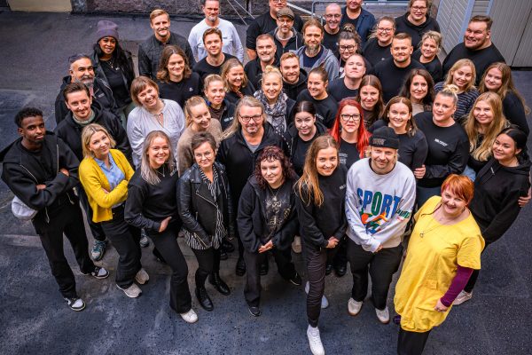 Viitisenkymmentä ihmistä  katsoo kameraan yläviistosta otetussa ryhmäkuvassa
