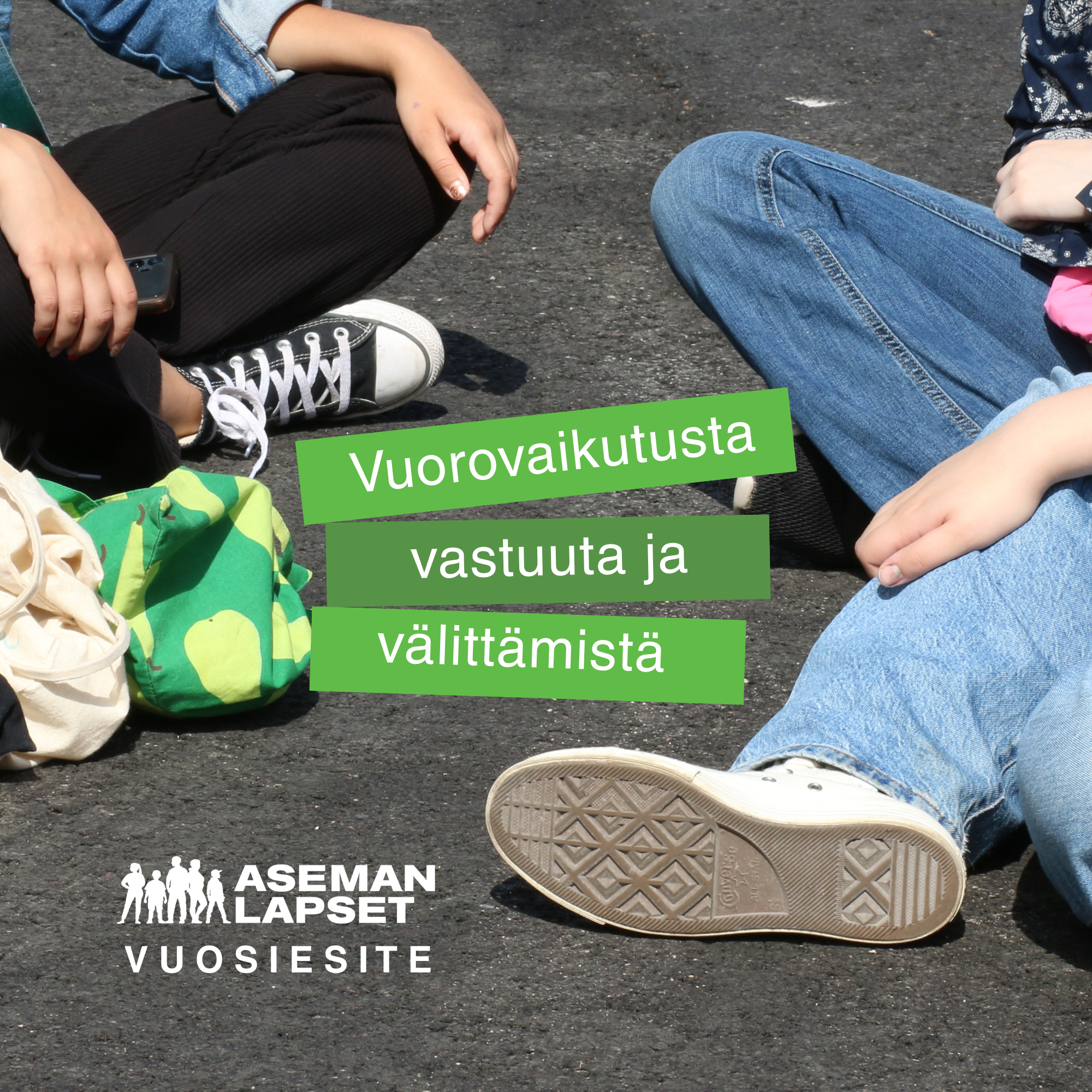 Porukka nuoria istuu kesäisellä asfaltilla