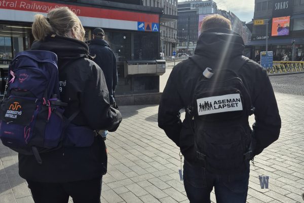 Jalkautumassa nuorten pariin, kaksi aikuista kävelee reput selässä Helsingin keskustasa.
